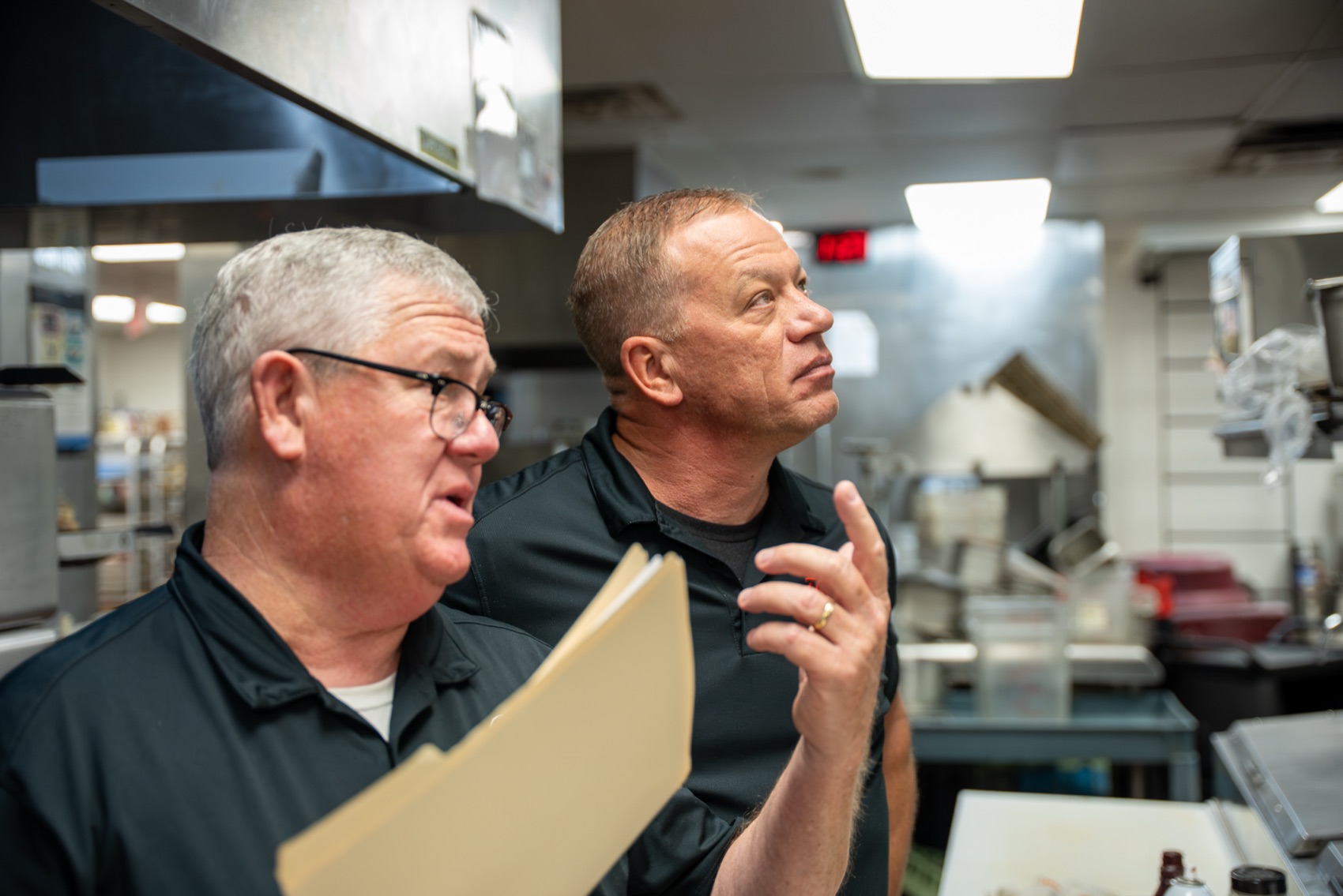 Dave Duff and Bengi Crosby walking a member kitchen with an order file
